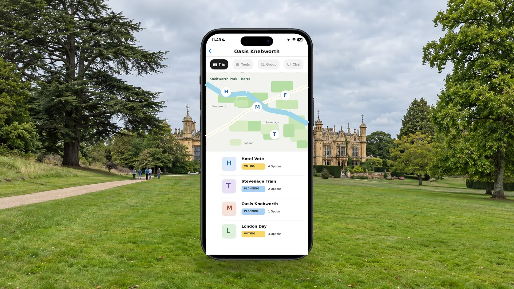 FlowTrip Oasis Knebworth trip plan on a phone in Knebworth Park with the house behind it